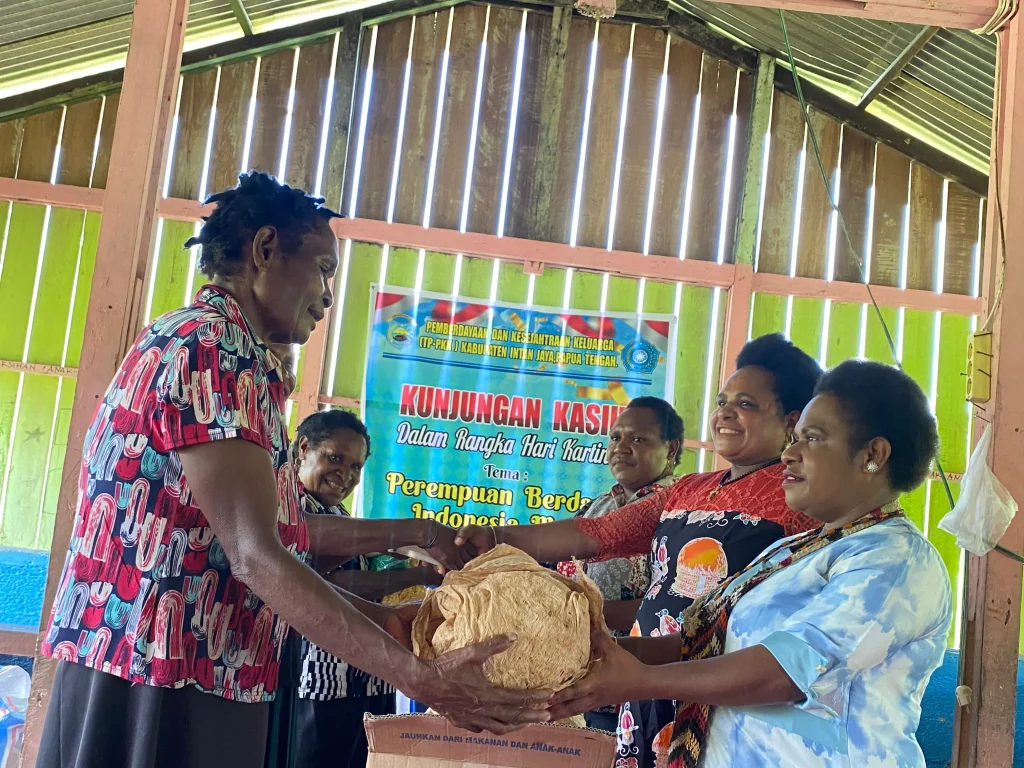 Ketua TP PKK Intan Jaya didampingi Ibu Wakil Ketua dan Bendahara TP PKK Intan Jaya saat menyerahkan bahan dasar kerajinan tangan kepada Kelompok Pengrajin Mene Mita Ombo.